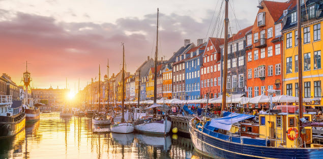 Colorful waterfront houses and moored boats at Nyhavn, Copenhagen, at sunset